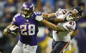 Vikings running back Adrian Peterson takes the ball for 21 yards as he stiff arms Bears free safety Chris Conte in overtime. Peterson ran for 211 yards on 35 carries, and broke the 10,000-yard career rushing mark. (Pioneer Press: Ben Garvin)