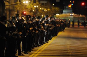 LOS ANGELES, CA - NOVEMBER 28:  Hundreds of Los Angeles Police Officers in riot gear form a skirmish line as they attempt to clear the streets around Los Angeles City Hall of Occupy LA demonstrators after the deadline to dismantle the occupy campsite expired on November 28, 2011 in Los Angeles, California. Los Angeles Mayor Antonio Villaraigosa last week gave the protesters outside City Hall until 12:01 am today to dismantle their protest campsite and leave.  (Photo by Kevork Djansezian/Getty Images)